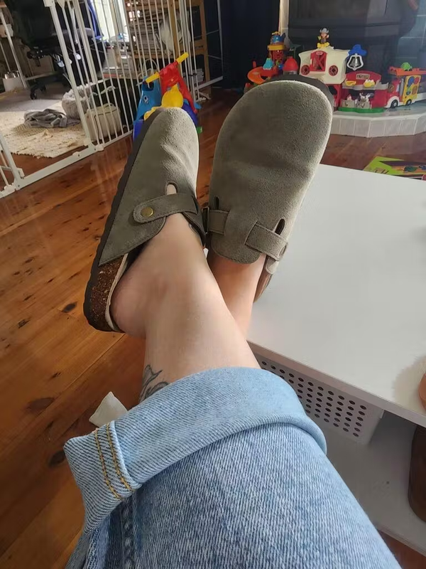 Customer relaxing in olive suede clogs